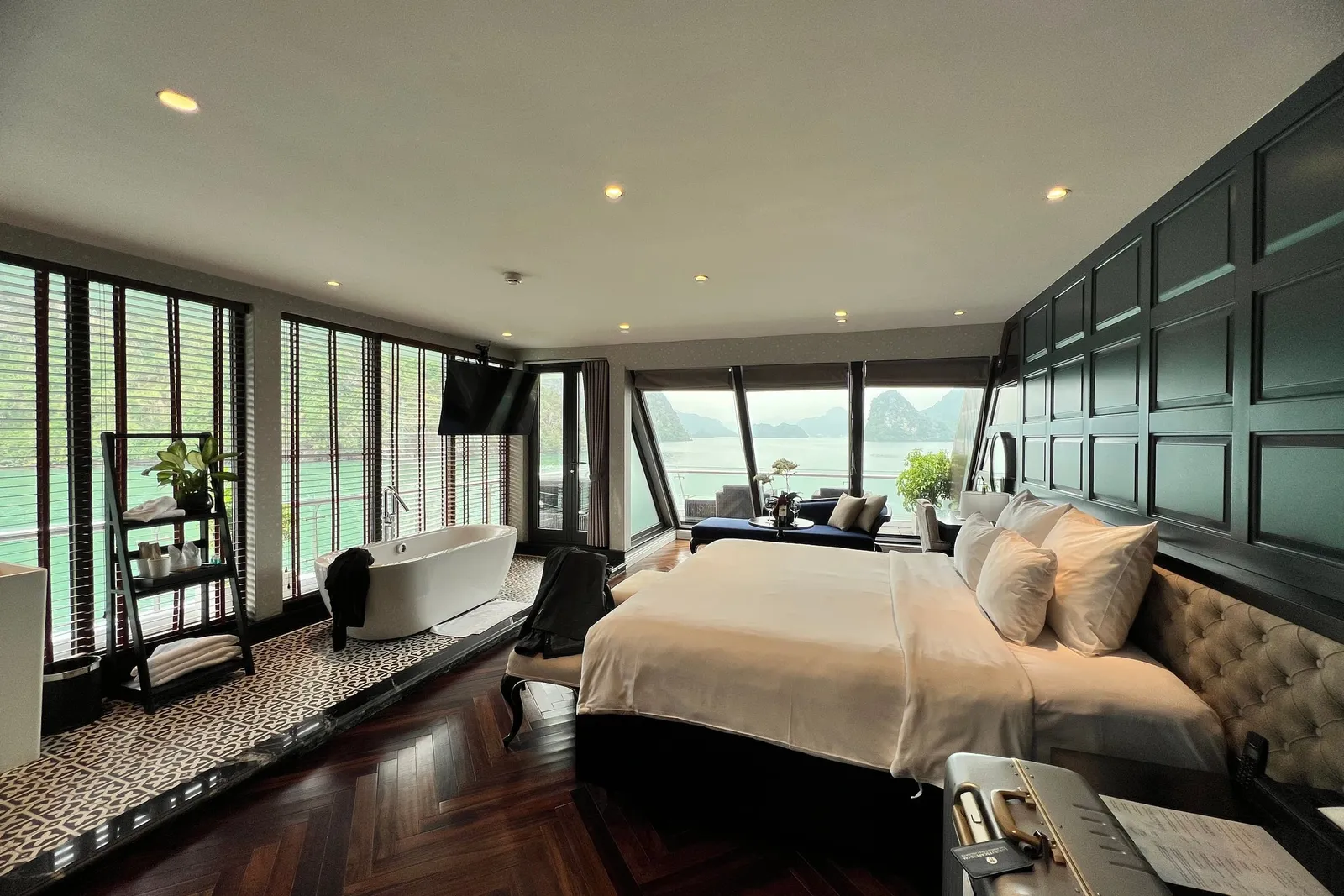 Suite with a freestanding bath beside the bed and glass running the full width onto the bay