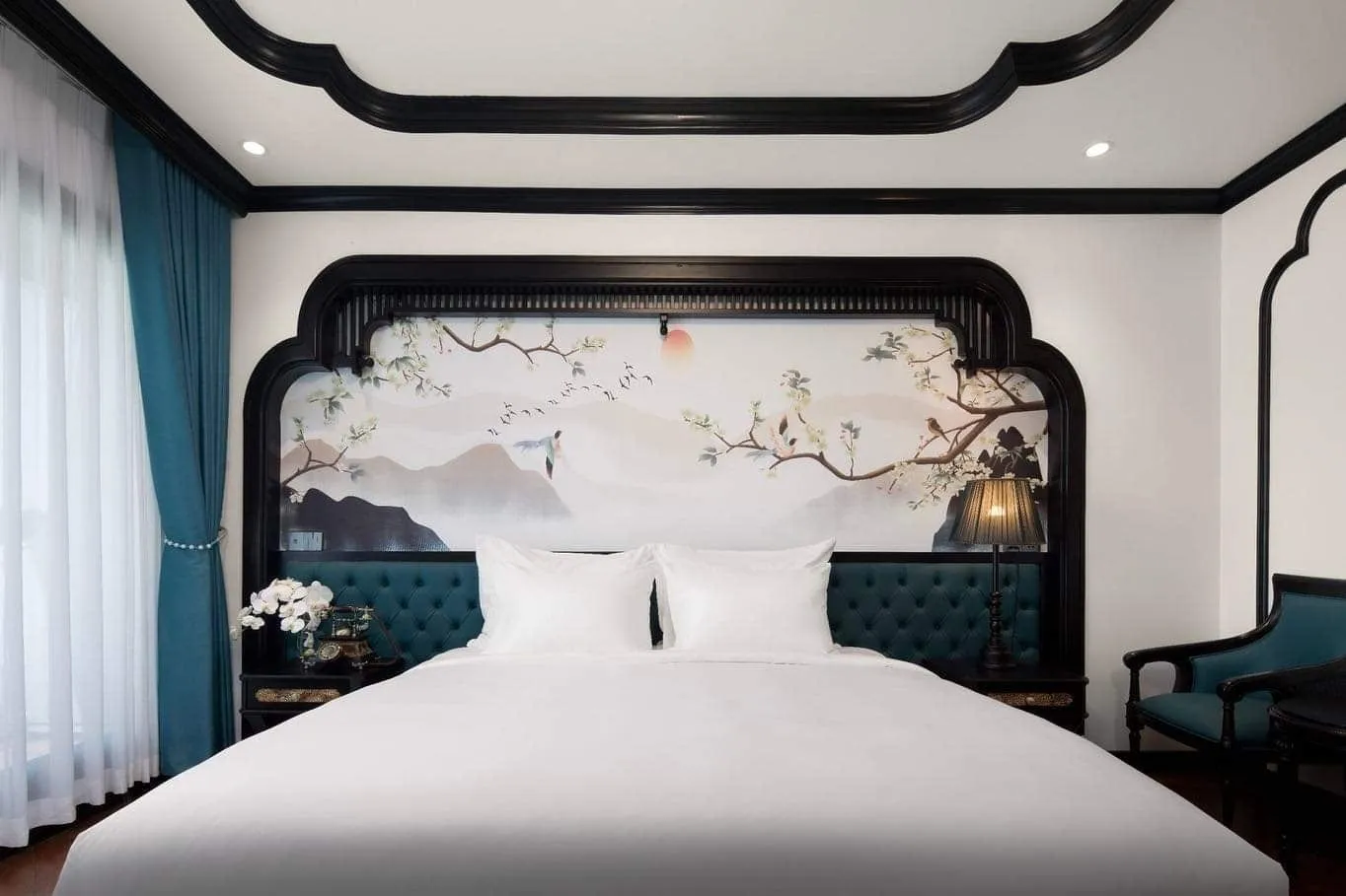Cabin with a hand-painted blossom panel over the bed and a buttoned teal headboard