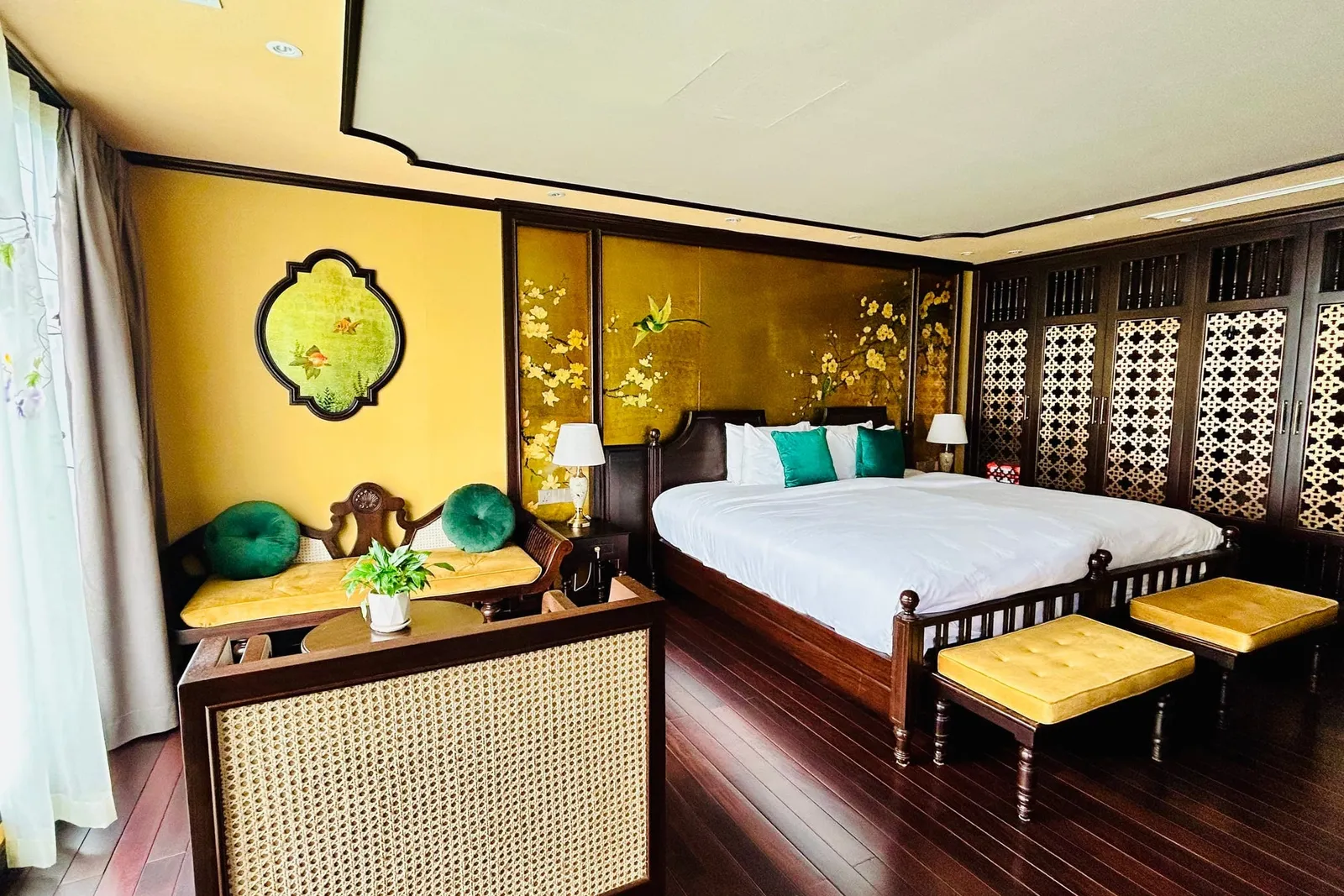 Cabin with mustard walls and carved lattice screens, a bench at the foot of the bed