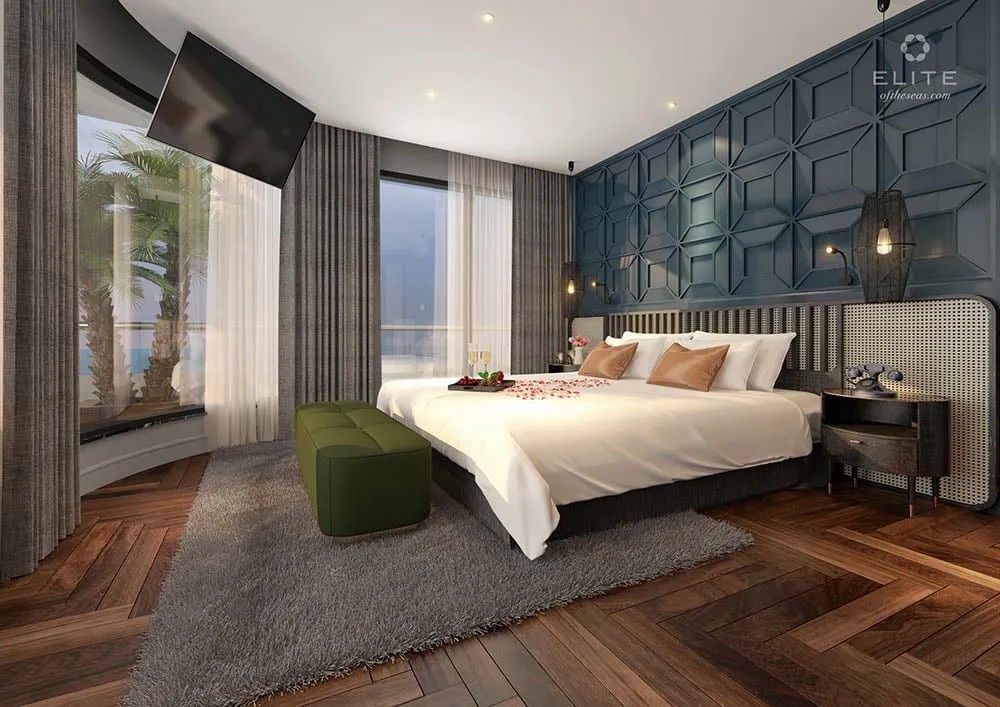 Cabin with a moss green ottoman at the foot of the bed and a panelled headboard wall behind