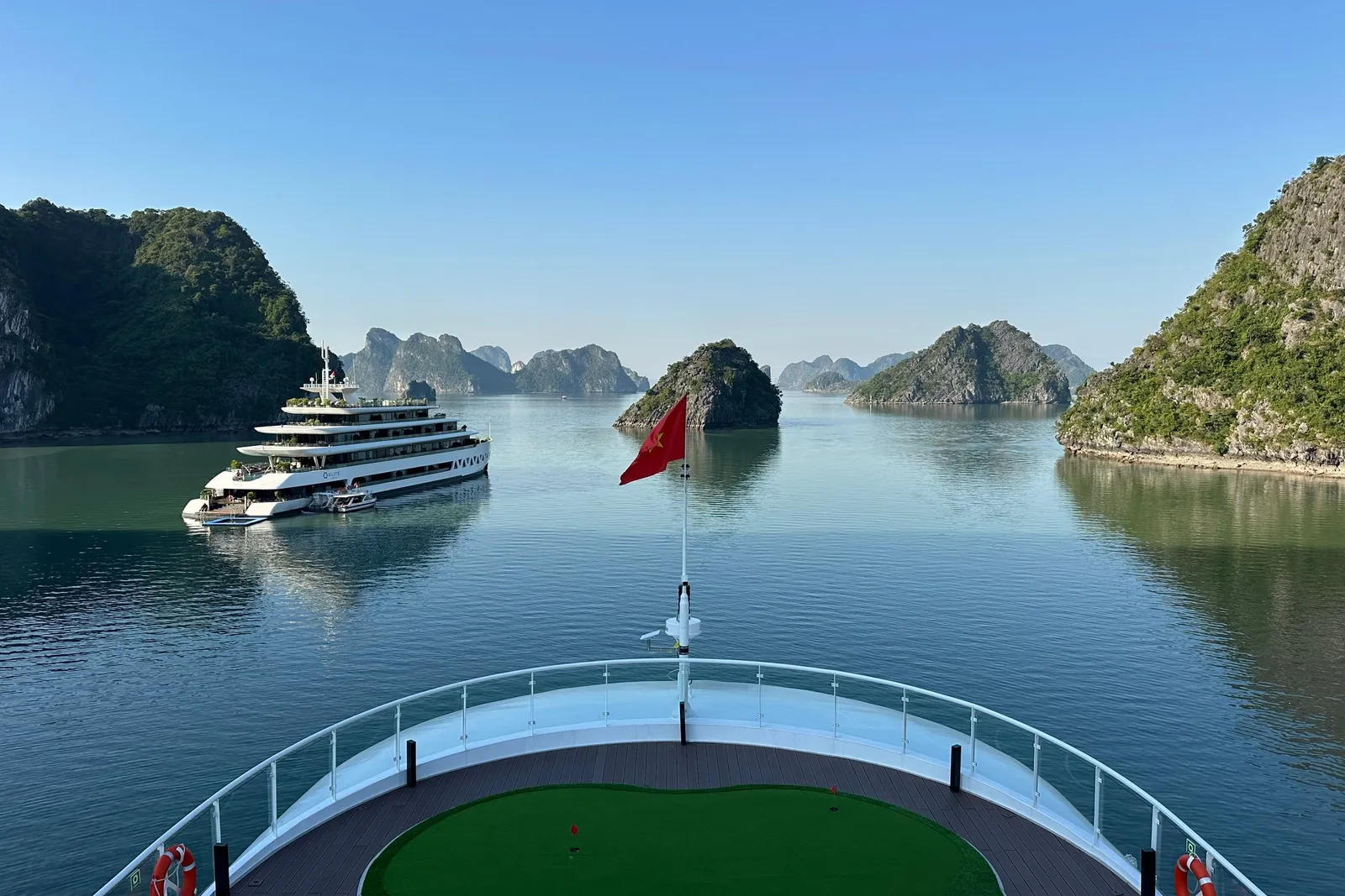 Looking forward over the putting turf on the foredeck, the flag up and karst either side of the channel