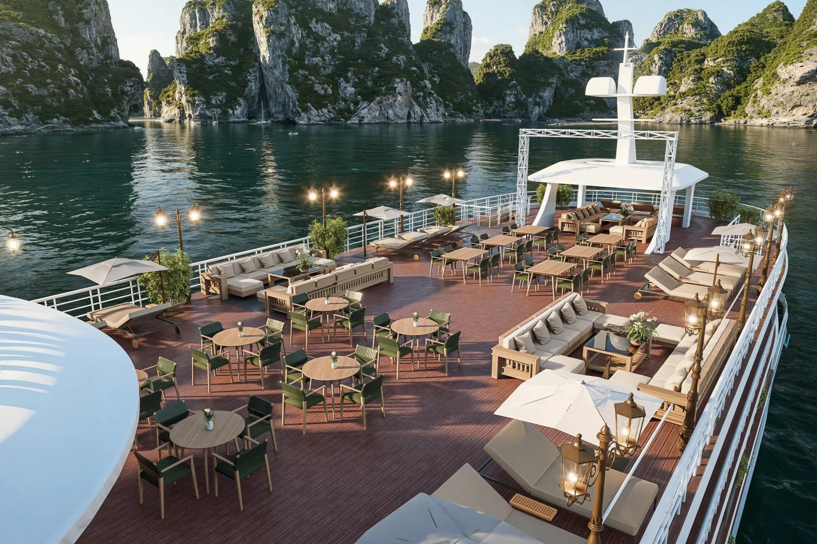 A cruise ship's wooden sundeck with dining tables, lounge seating, and lighting fixtures surrounded by limestone karst islands and calm green water.