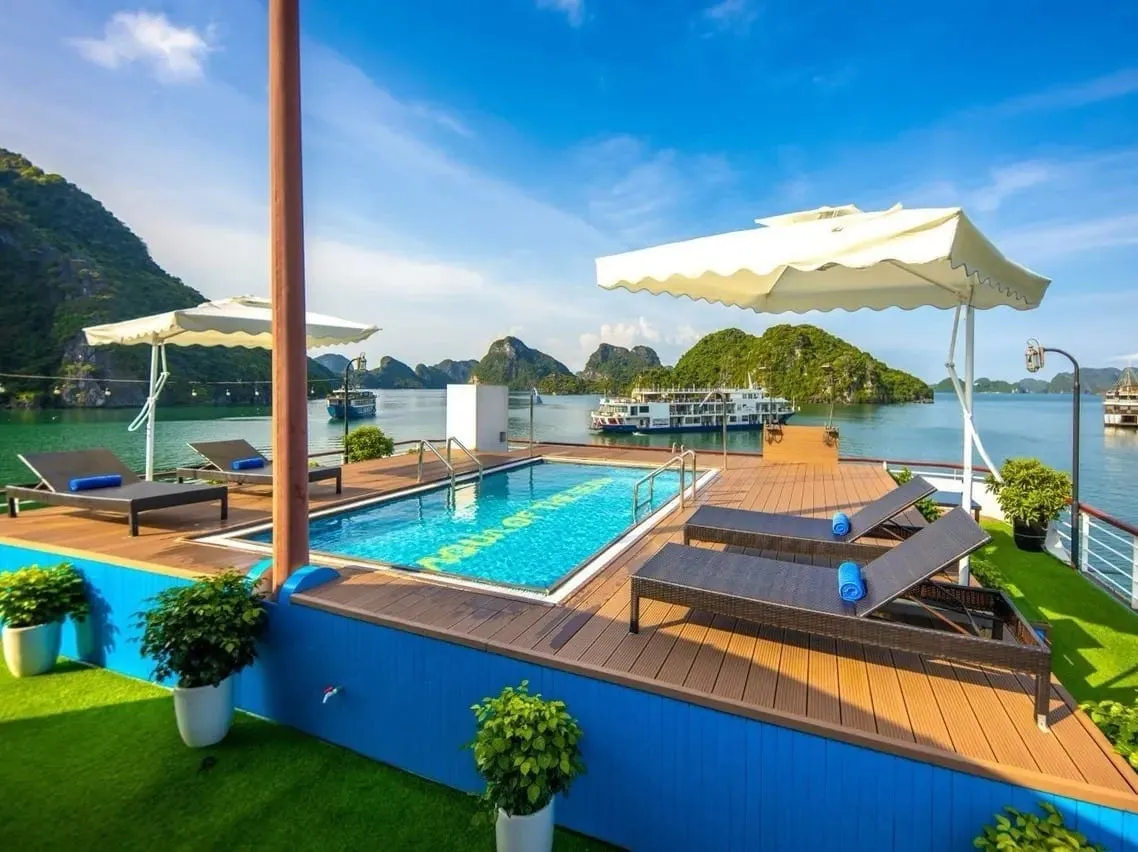 Sundeck pool with white umbrellas and loungers, other cruise boats at anchor across the channel