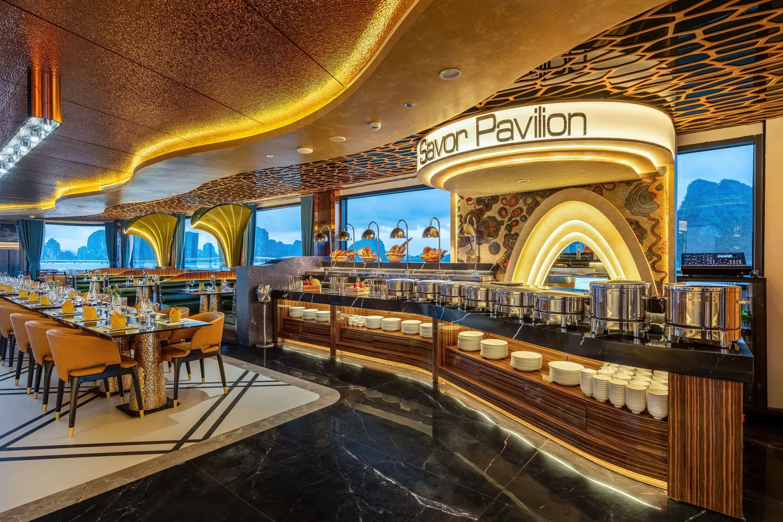 Buffet pavilion with a gold arch over the counter, mustard chairs at set tables and the bay through the windows