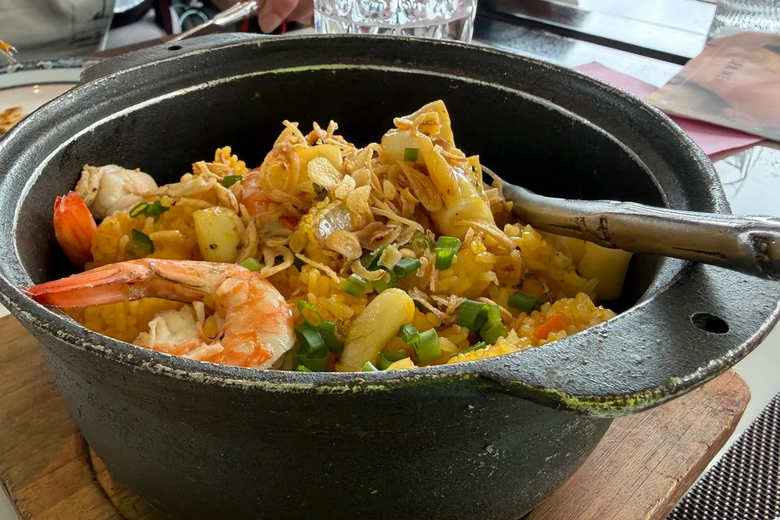 Cast-iron pot of seafood and vegetables brought to the table