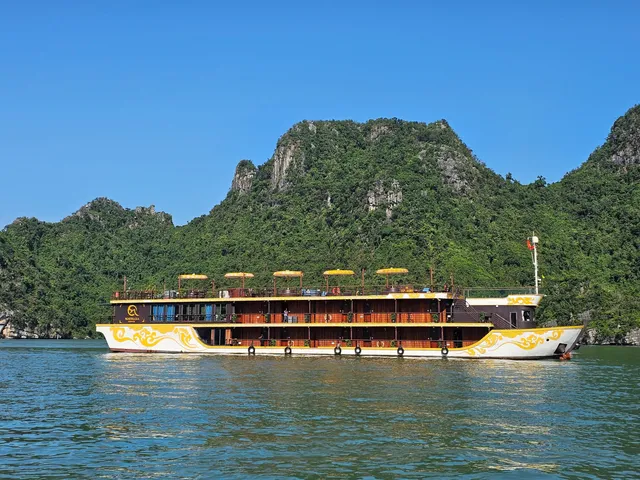 Nostalgia side on under way, cream and gold hull with a row of yellow parasols along the top deck