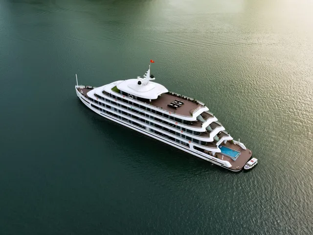 Catherine seen straight down from the air, five white decks and a pool on the stern, alone on olive-green water
