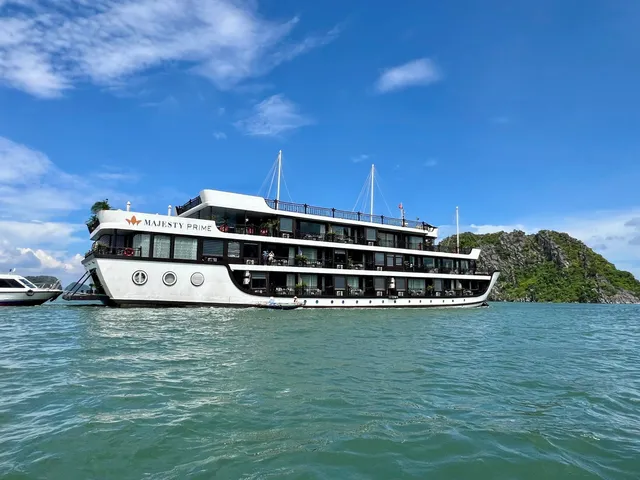 Majesty Prime broadside on turquoise water, the ship name on a white hull below three decks of windows