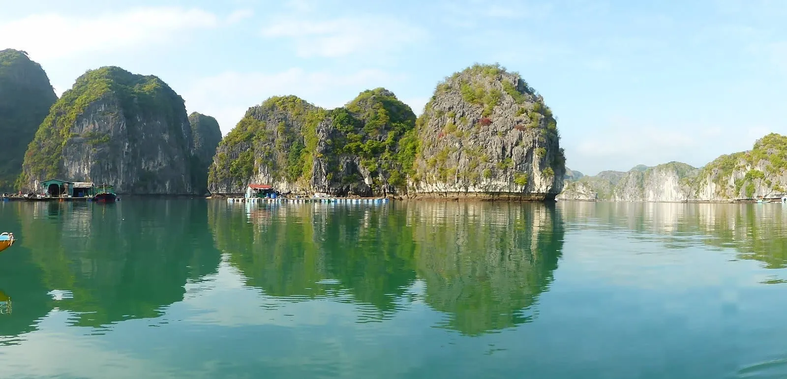 Limestone islands reflected in calm water in Lan Ha Bay