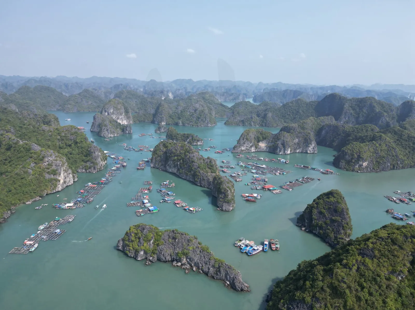 Aerial view of Lan Ha Bay off Cat Ba, with floating fish farms among limestone islands